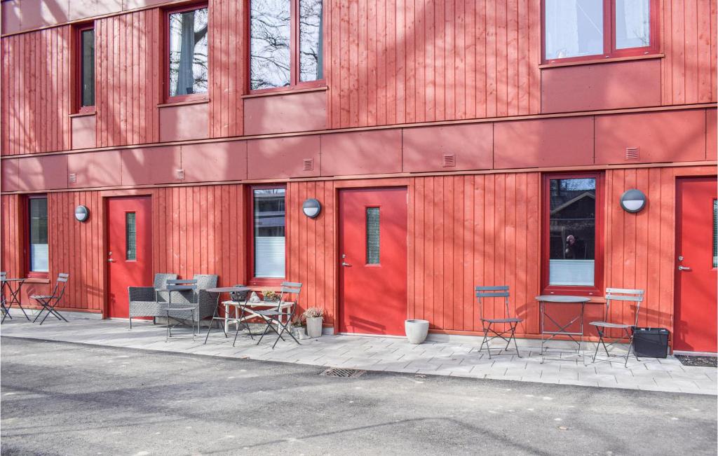 a red building with tables and chairs in front of it at Stunning Apartment In Frjestaden With Wifi in Färjestaden