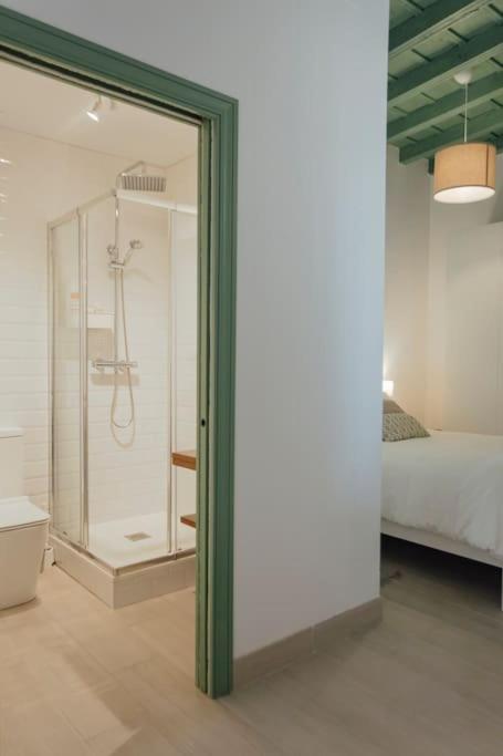W łazience znajduje się prysznic, łóżko i lustro. w obiekcie Komodo Gran Poder - Penthouse with Private Pool and Cozy twin bedroom central Apartment w Sewilli