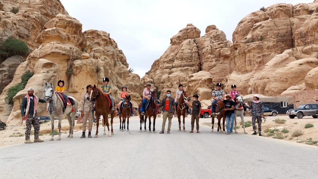 a group of people on horses in the desert at Petra Royal Ranch in Wadi Musa