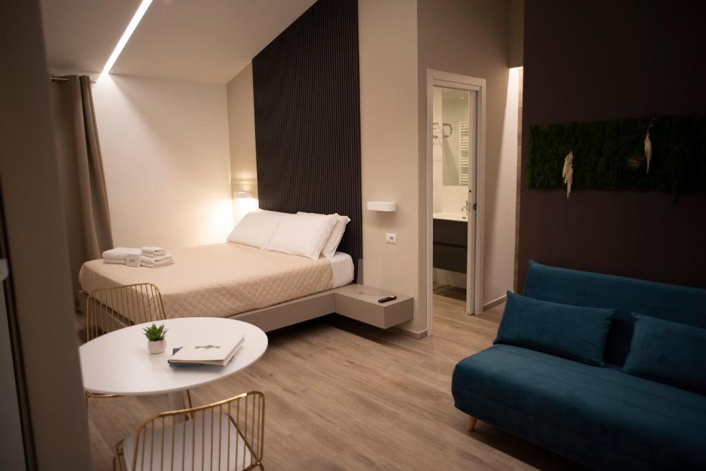 Habitación pequeña con cama, mesa y sofá. en House Room Civico 56, en Crotone