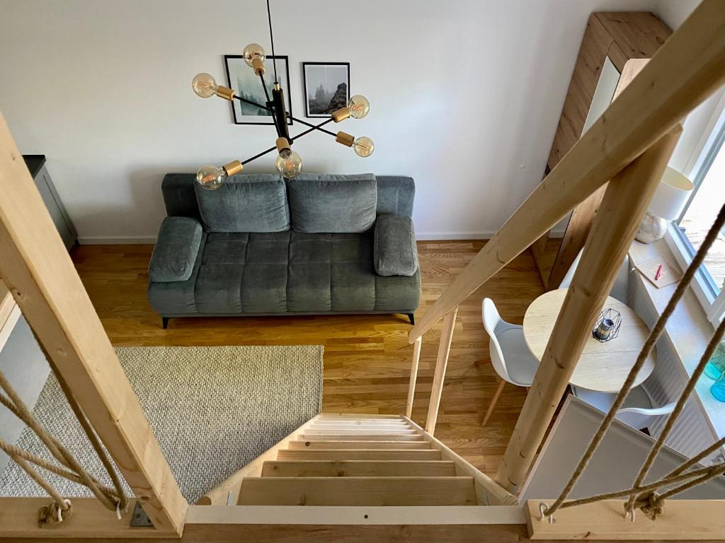 a living room with a couch and a staircase at Galerie Apartment Self-Check-In in Kolbermoor