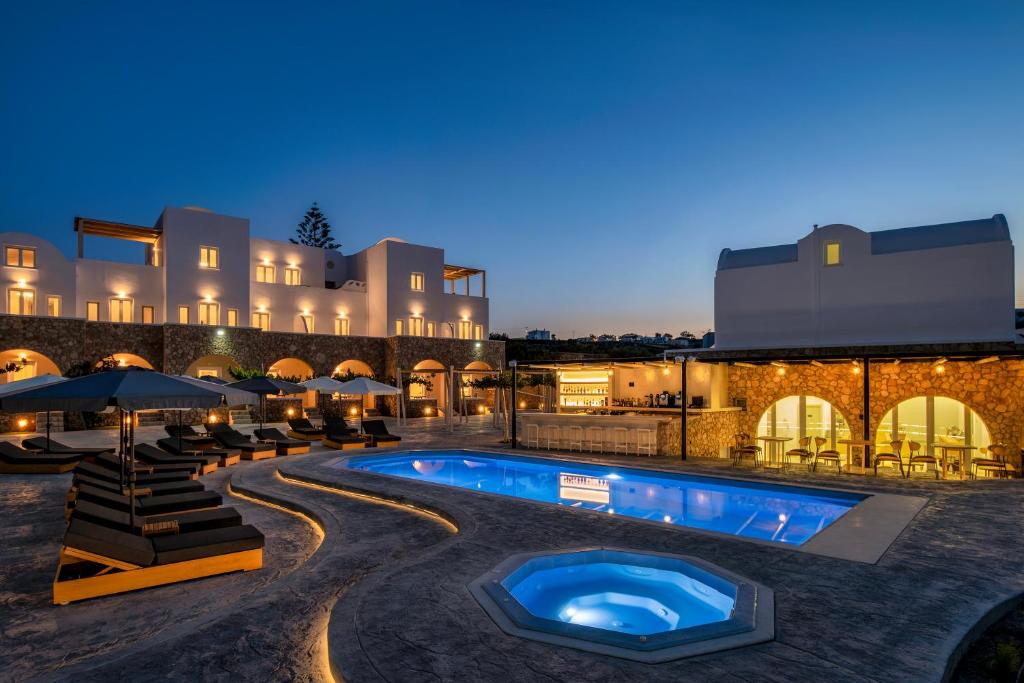 a resort with a swimming pool at night at Aelia Luxury Suites in Karterados