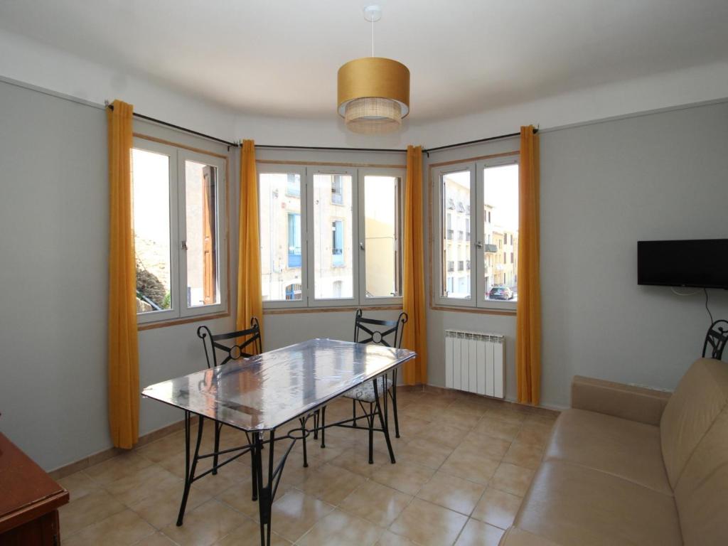 uma sala de estar com uma mesa e um sofá em Appartement Port-Vendres, 3 pièces, 4 personnes - FR-1-309-325 em Port-Vendres