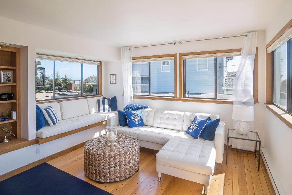 a living room with two white couches and blue pillows at Calle Paradise in Stinson Beach