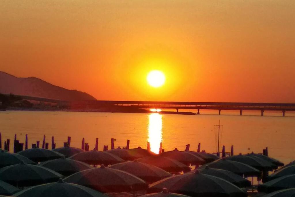 un coucher de soleil sur une étendue d'eau avec des bateaux et un pont dans l'établissement La culla sul mare in centro, à Manfredonia