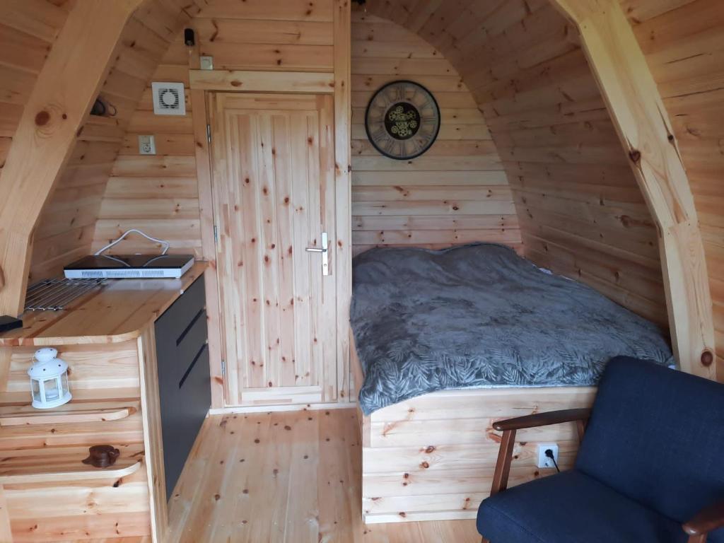 een kleine slaapkamer in een blokhut met een bed bij Vakantiehuisjes Marsherne in Poppingawier