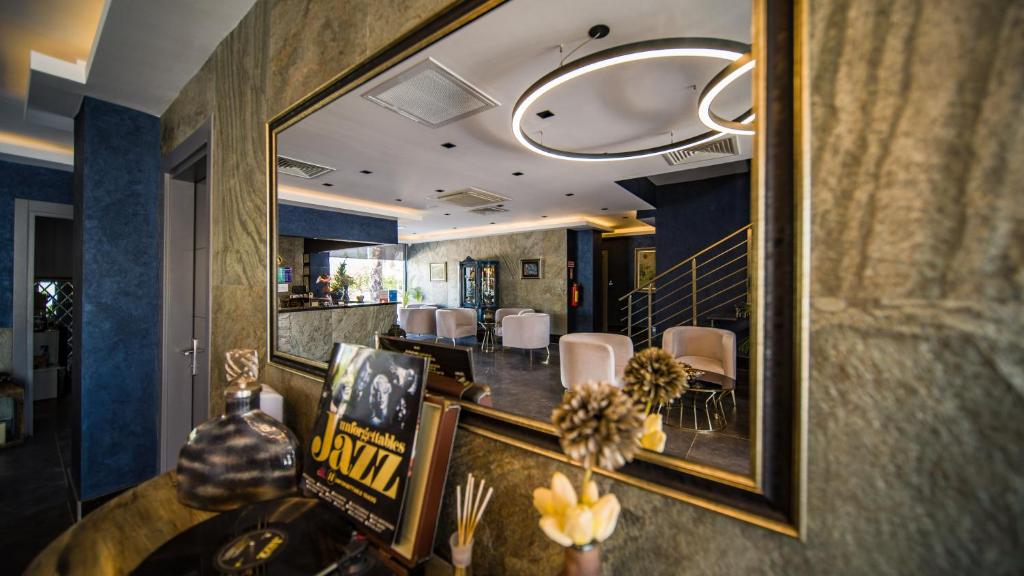 a dining room with a mirror and a table and chairs at Sea Palm Otel Yalıkavak in Yalıkavak