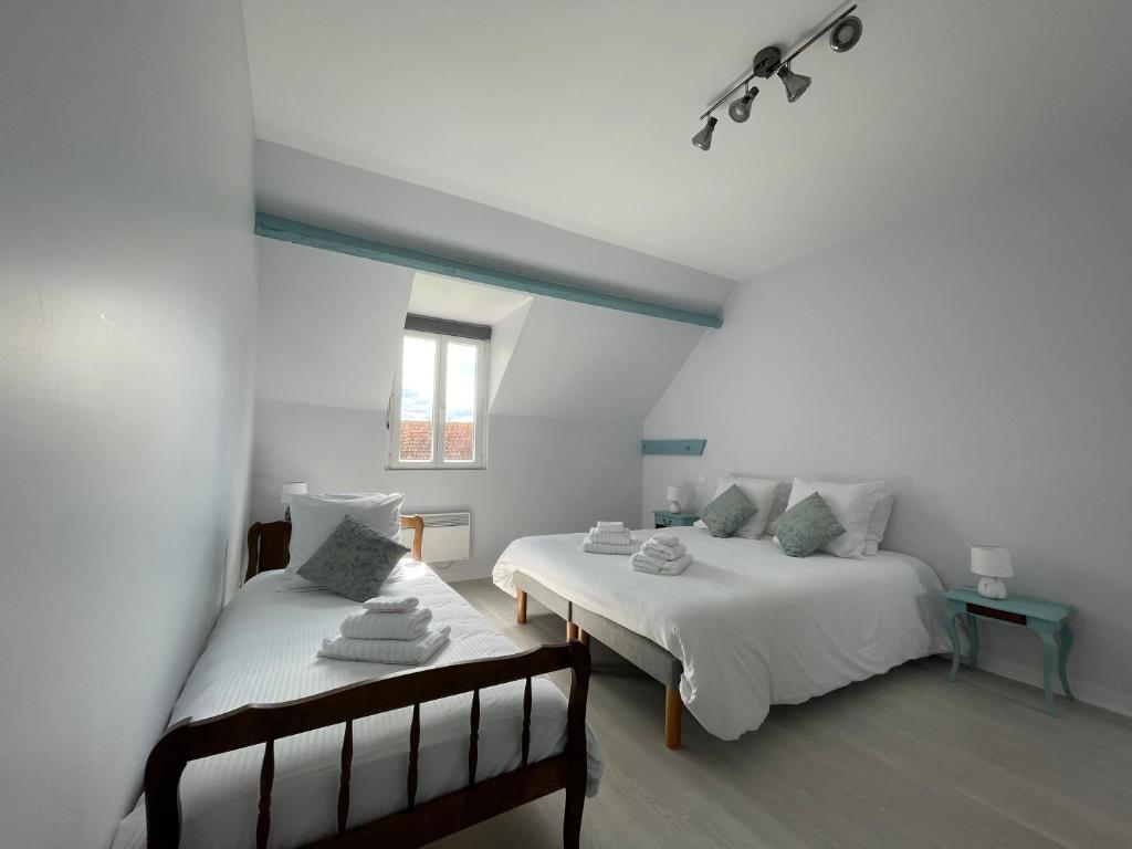 a bedroom with two beds and a window at Gold - Ferme Delaunay in Saint-Côme-du-Mont