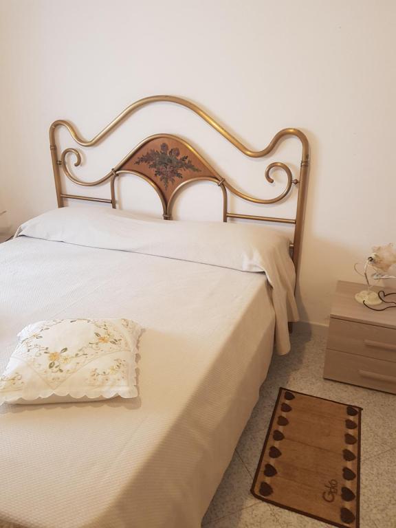 スカウリにある"Il nespolo"の白いベッド1台(木製ヘッドボード付)が備わるベッドルーム1室が備わります。