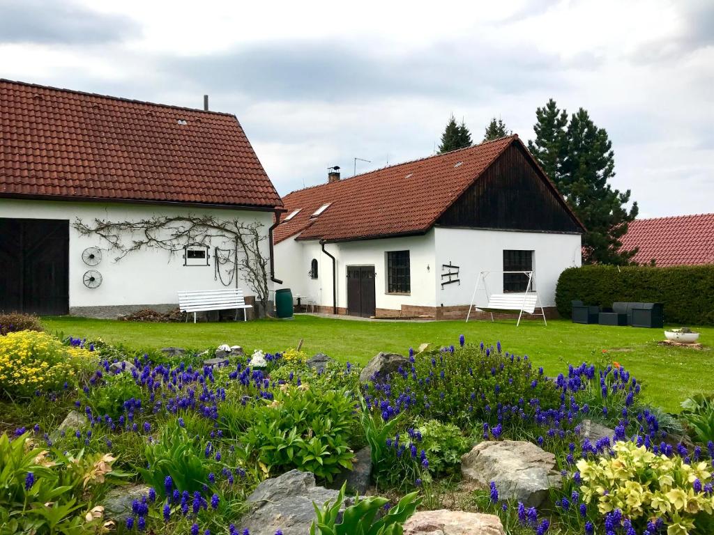 Biały dom z kwiatami w ogrodzie w obiekcie Venkovská usedlost Horšice w mieście Horšice