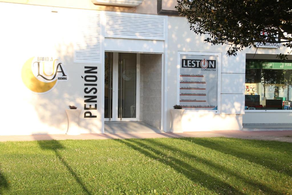 una tienda con un cartel delante de un patio en Baixo a Lua Rooming, en Sarria