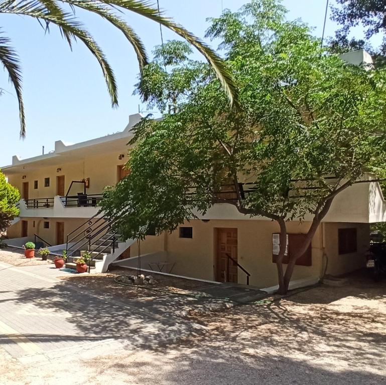 a building with a tree in front of it at Beach Side Apartments in Dhrepanon