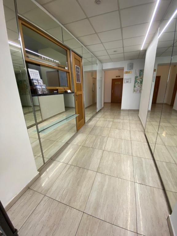 um corredor vazio de um edifício de escritórios com piso de madeira em Hotel Omega Brno em Brno