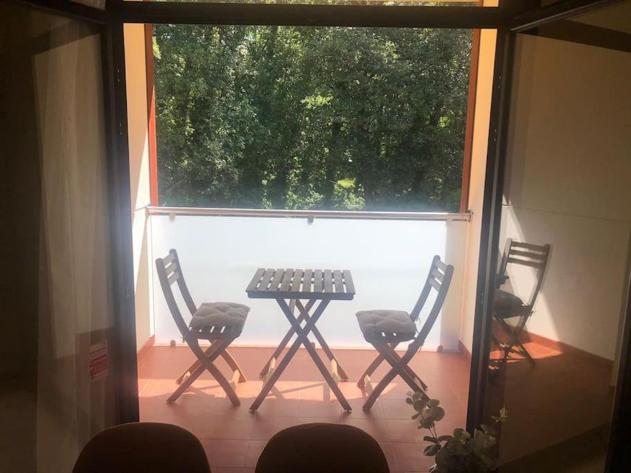 een patio met 2 stoelen en een tafel voor een raam bij Apartamento MIRABOSQUE - plaza garaje incluida in Arenas de San Pedro