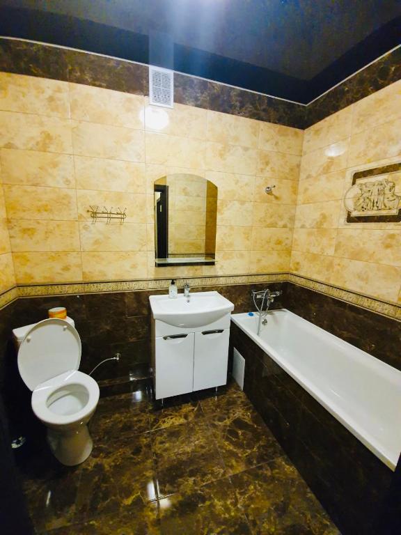 a bathroom with a toilet and a sink and a tub at PortCity in Lutsk