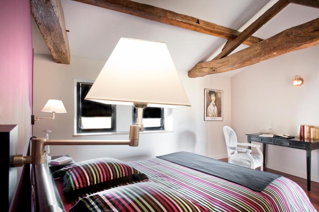 um quarto com uma cama com um candeeiro em La Villa des Forges em Legé