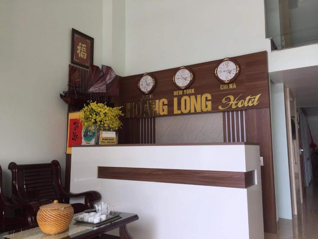 a living room with a long long table and clocks on the wall at Hoang Long Hotel Bai Chay in Ha Long