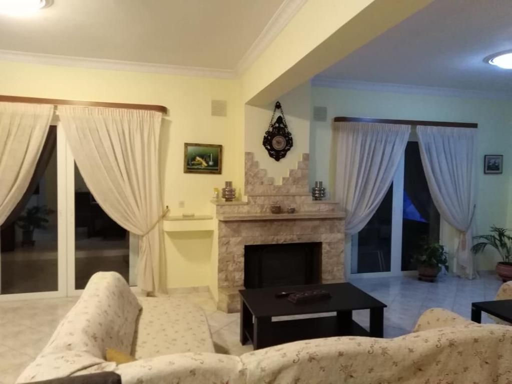 a living room with a couch and a fireplace at Alexadra's house Κάτω Αλμυρή in Káto Almirí