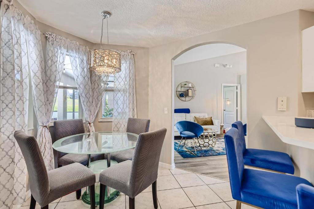 a dining room with a glass table and chairs at NEW Modern Relaxing 4 Bedroom Pool Villa Near Disney's Parks in Davenport
