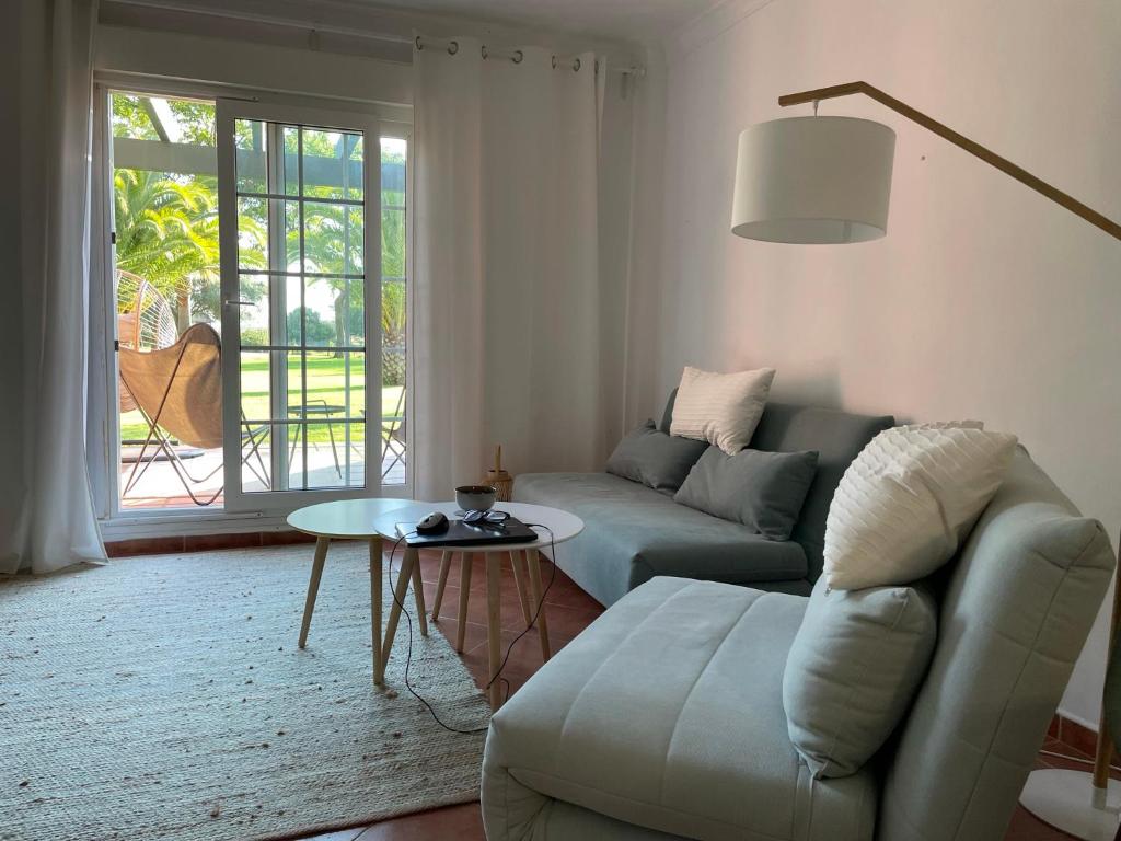 sala de estar con sofá y mesa en Charming apartment, golf, kitesurfing, free tennis courts and bikes en Isla Canela
