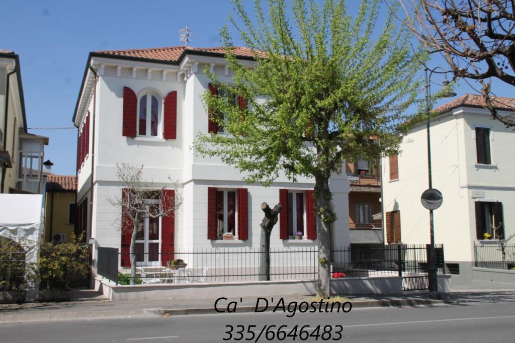 una casa bianca con una statua davanti di Ca' D'Agostino a Battaglia Terme