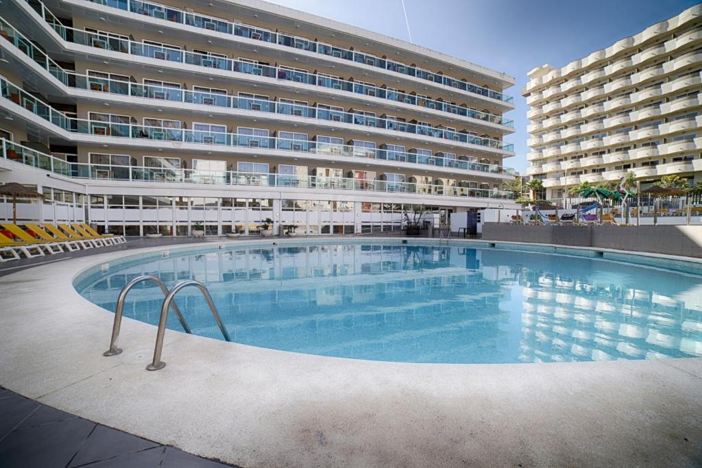 a large swimming pool in front of a building at Ohtels Villa Dorada in Salou