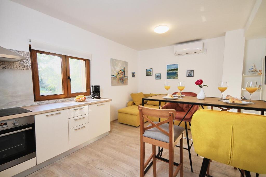 een keuken en een woonkamer met een tafel en stoelen bij Apartman Lanterna in Viskovo