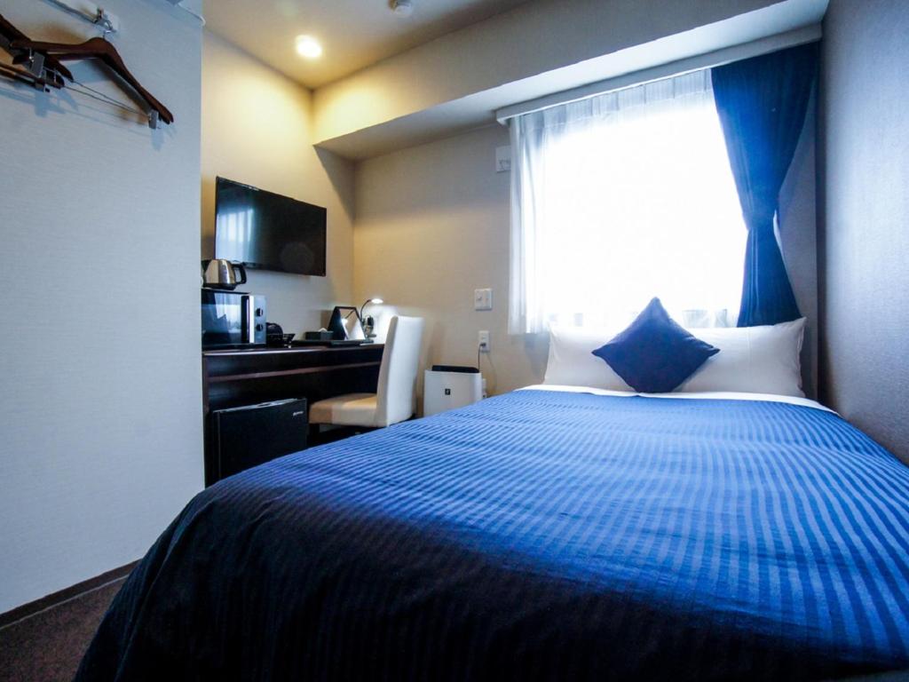 Postel nebo postele na pokoji v ubytování HOTEL LiVEMAX Kasai Ekimae