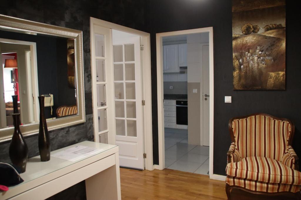 a living room with a chair and a mirror at casa da praia in Vila do Conde