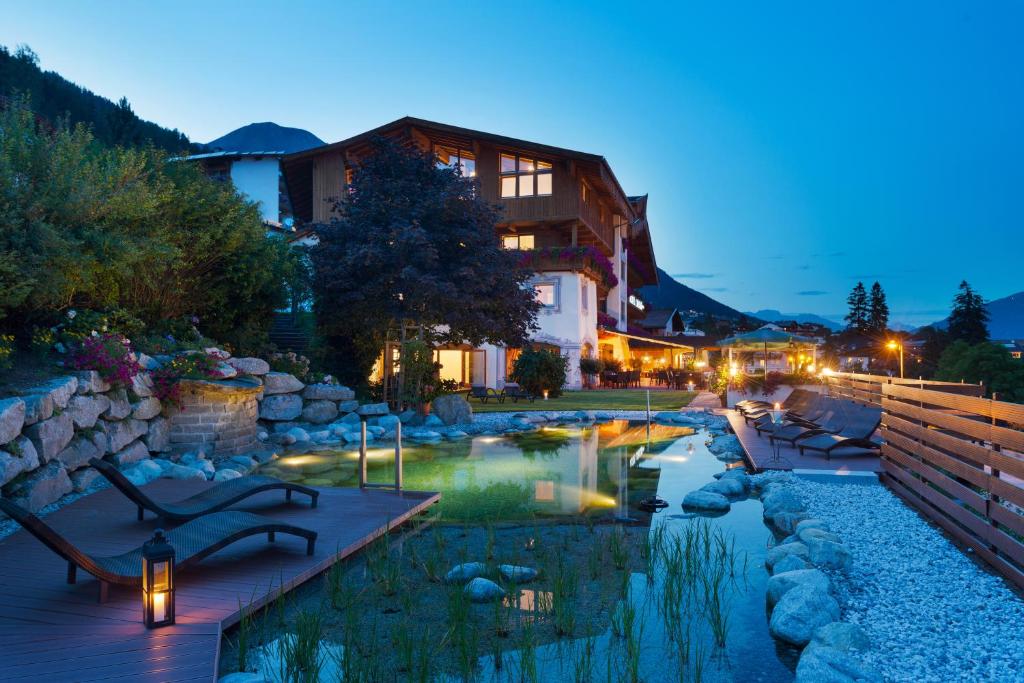 un hôtel avec une piscine en face d'un bâtiment dans l'établissement Sporthotel Cristall, à Fulpmes