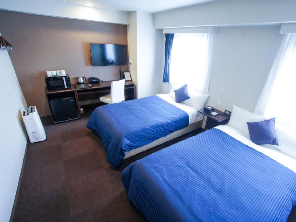 Postel nebo postele na pokoji v ubytování HOTEL LiVEMAX Kasai Ekimae