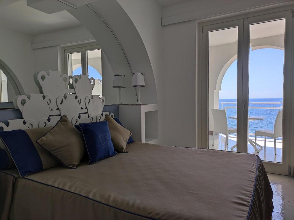 - une chambre avec un grand lit et une vue sur l'océan dans l'établissement Albergo Da Carmine, à Castellabate