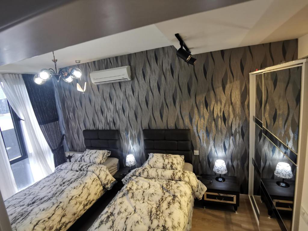 a bedroom with two beds and a wall with a wallpaper at My G yoo Apartment #2 in Istanbul