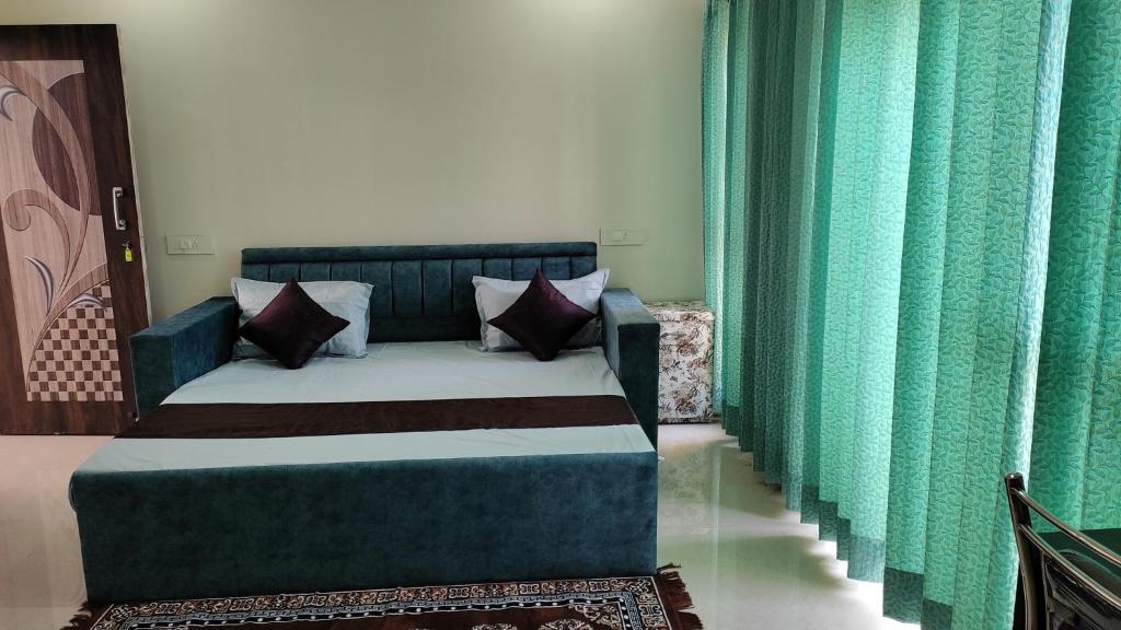 Cama en habitación con cortinas verdes en Krishnabalram Polyclinic Ayurveda centre en Rishīkesh
