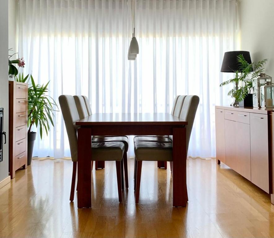 a wooden table and chairs in a room at Yellow Five Apartment in Ponta Delgada