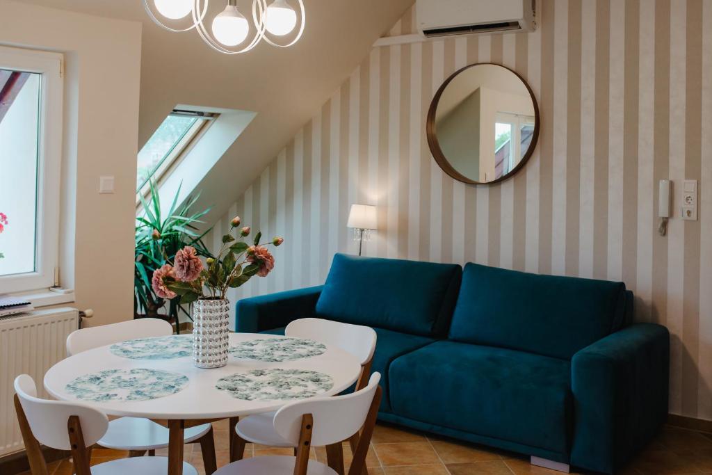 ein Wohnzimmer mit einem blauen Sofa und einem Tisch in der Unterkunft Kamilla Apartman in Makó