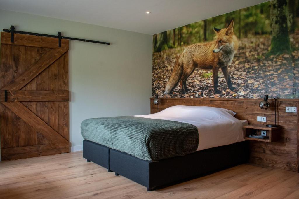 a bedroom with a bed and a painting of a fox at Hotel B&B Buiten Loon in Loon op Zand