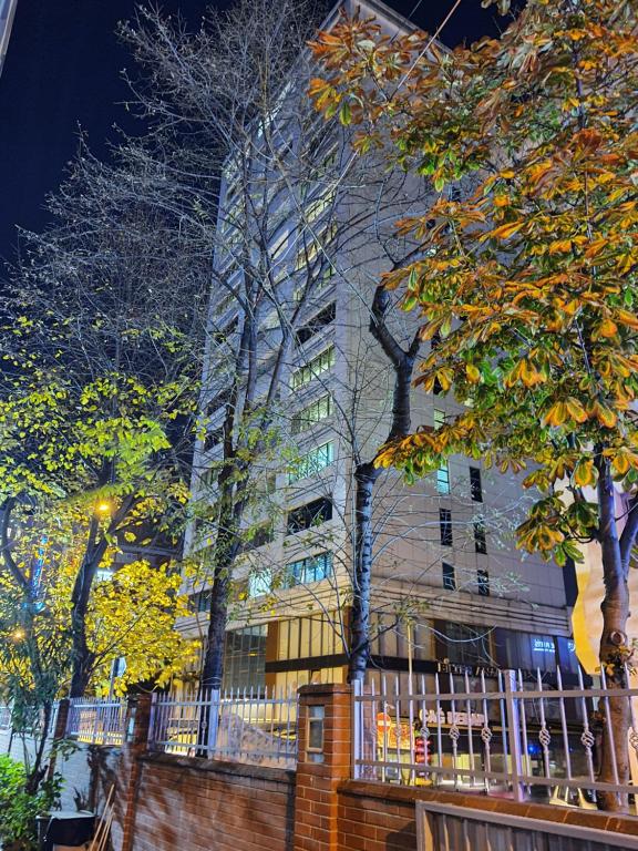 un edificio alto con árboles delante de él en Academia Residence, en Estambul