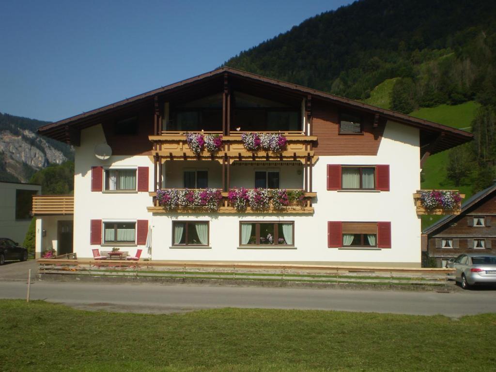 un bâtiment avec des boîtes de fleurs sur son côté dans l'établissement Gästehaus Manuela Puchmayr, à Mellau