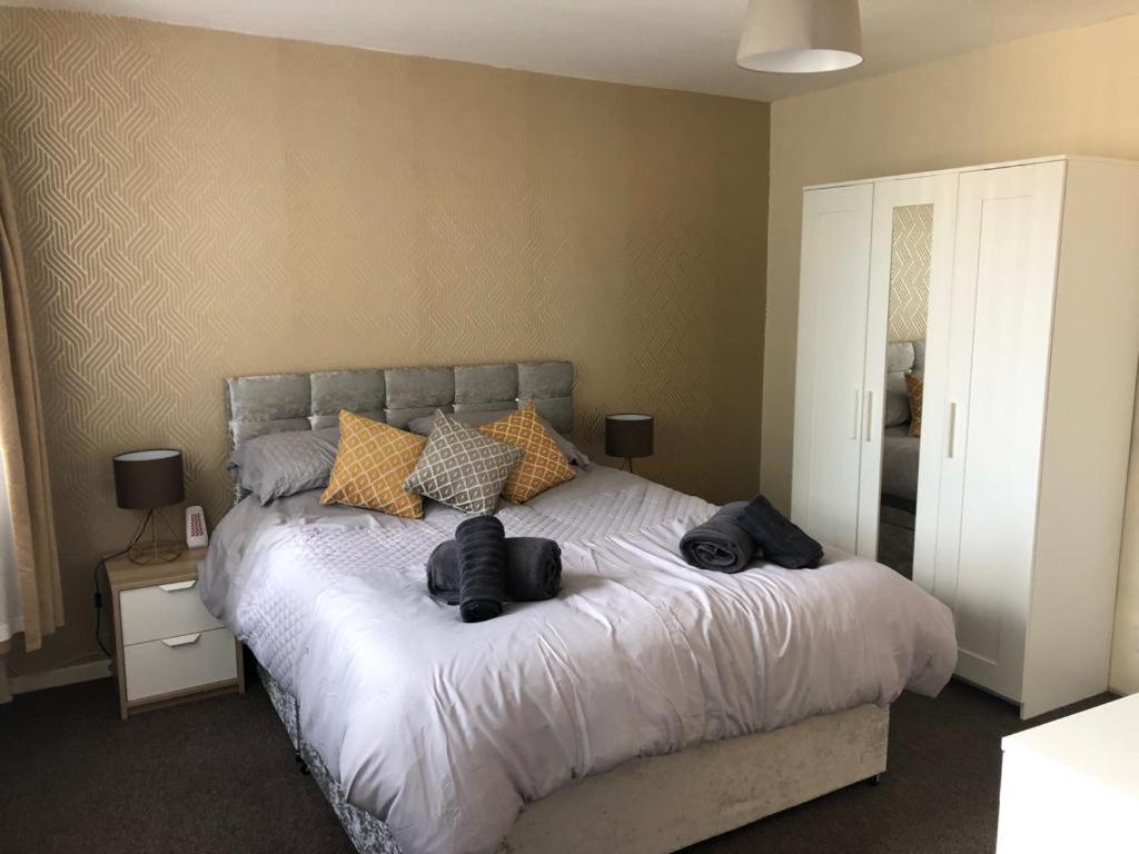 sypialnia z dużym łóżkiem z dwoma ręcznikami w obiekcie Ainsdale Gardens w Birmingham