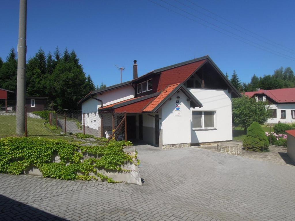 a white building with a red roof at Pension Úsvit in Podkopná Lhota