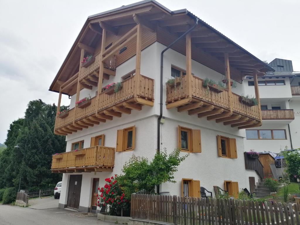 a white building with wooden balconies on it at Ciasa Rosada in San Vigilio Di Marebbe