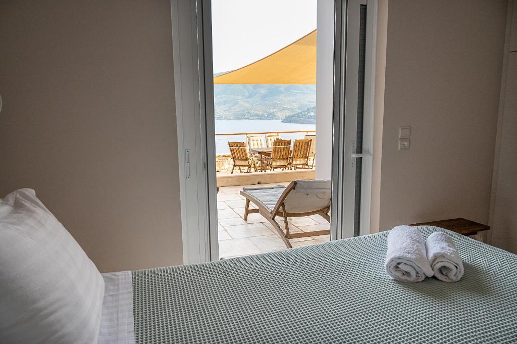 a bedroom with a bed with a view of a patio at Kalavria Luxury Suites, Afroditi Suite with magnificent sea view and private swimming pool. in Poros