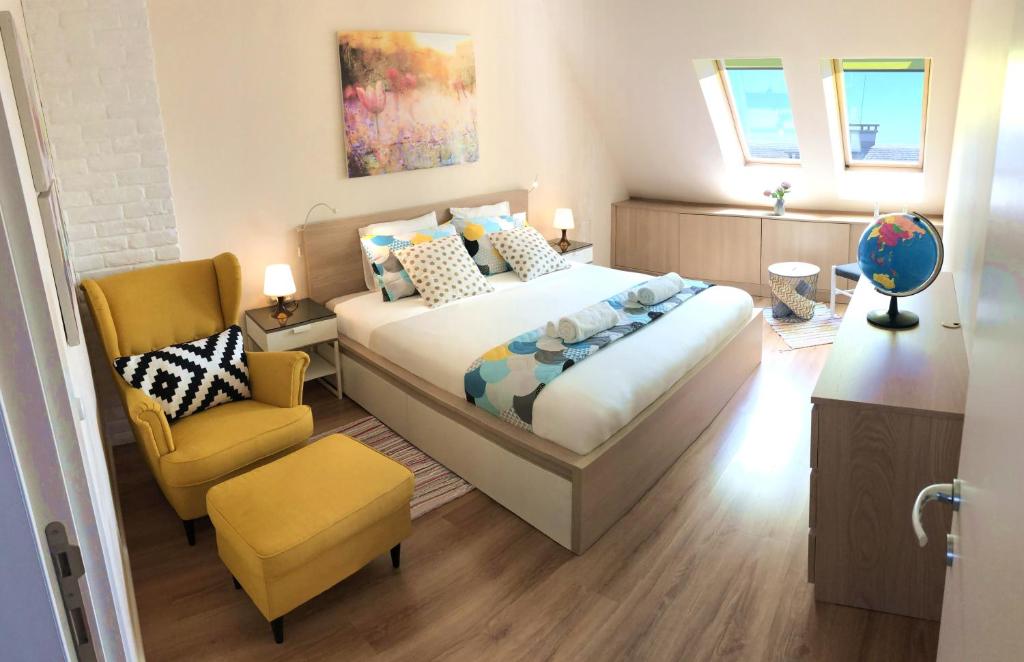 um quarto com uma cama grande e uma cadeira amarela em Unique Luxurious Jacuzzi PENTHOUSE DUPLEX in City Center! 2 BATHS! FREE PARKING! em Sófia