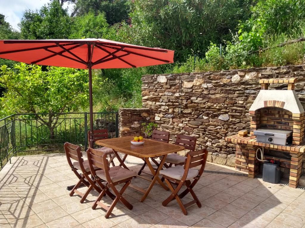 einen Holztisch und Stühle mit Sonnenschirm und Grill in der Unterkunft 6CHK4 Villa 6 personnes dans résidence in Collioure