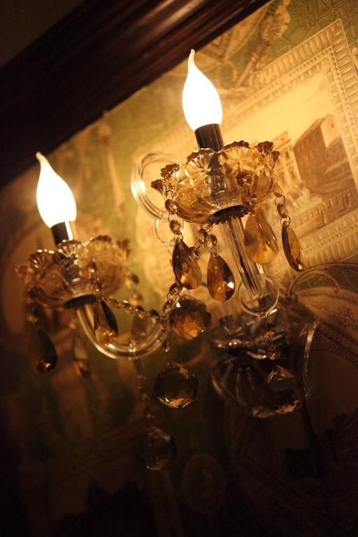 a chandelier with two candles in front of a mirror at Haut Rhin Villa in Zhuangwei