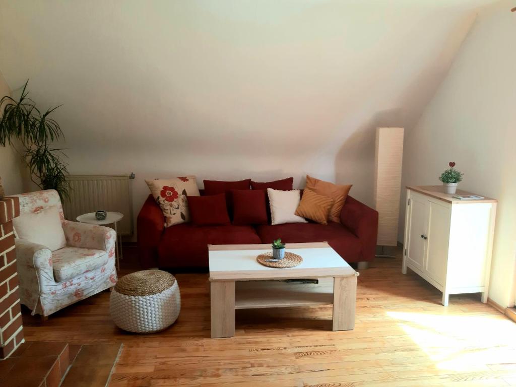 a living room with a red couch and a coffee table at Bonnys Ferienwohnung in Nohfelden