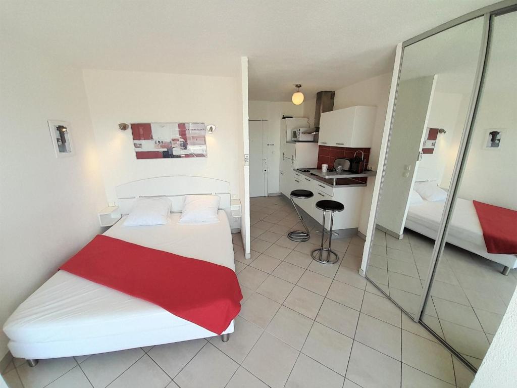 Cette petite chambre comprend un lit et une cuisine. dans l'établissement Studio Village Naturiste Carino, au Cap d'Agde