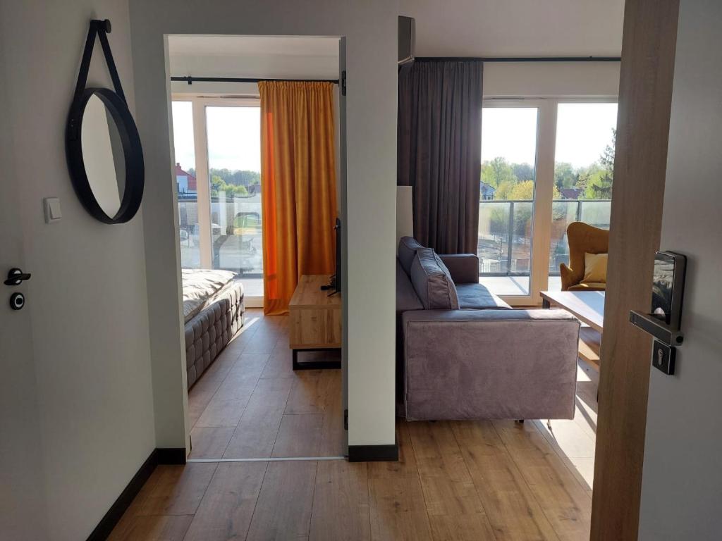 a view of a living room with a couch and a bed at Turystyczna Suite in Ostróda