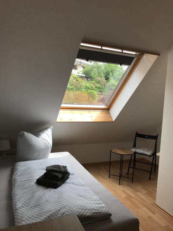 a bedroom with a bed with a window and a chair at EZ im Haus Maja in Holzkirchen